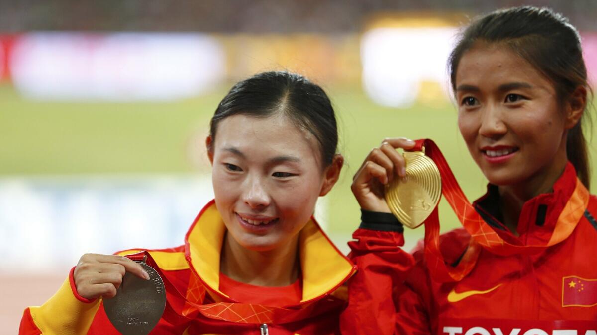 Lu Xiuzhi (left), silver medal, and Liu Hong, gold medal, after the women’s 20 km walk event. 