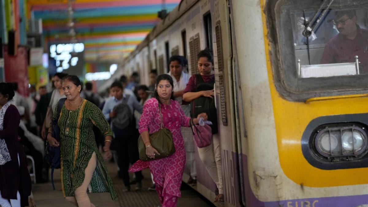 Women rush out of a train during peak hours at Churchgate station in Mumbai. — AP