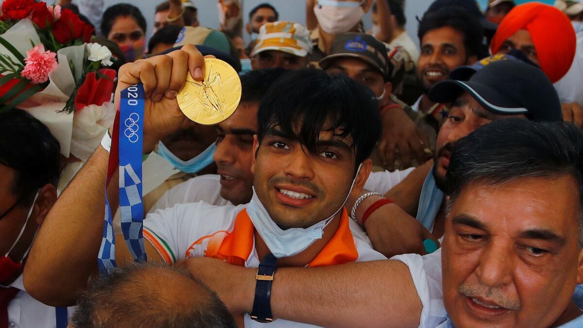 Gold medallist Neeraj Chopra shows his medal upon his arrival at the airport in New Delhi. — Reuters