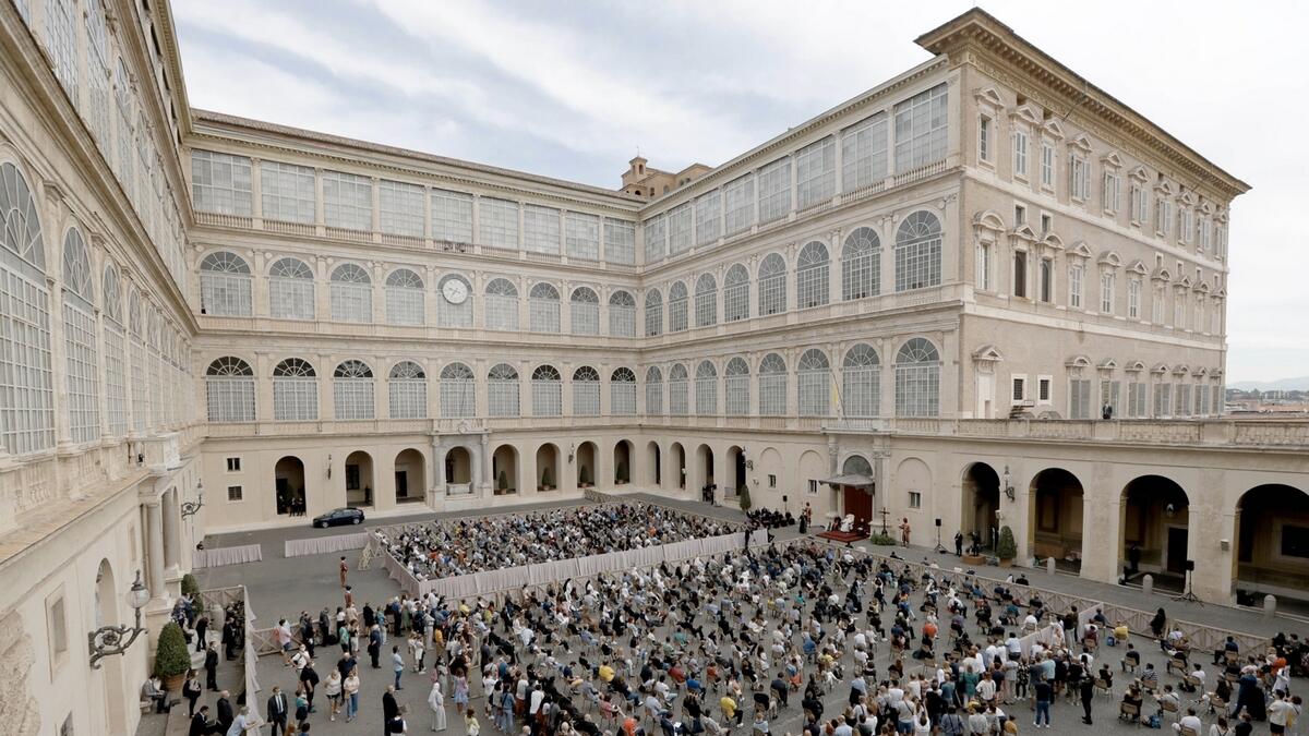 Faithful listen to Pope Francis, white figure sitting at center right, during his general audience, the first with faithful since February when the coronavirus outbreak broke out, at the San Damaso courtyard, at the Vatican. Photo: AP
