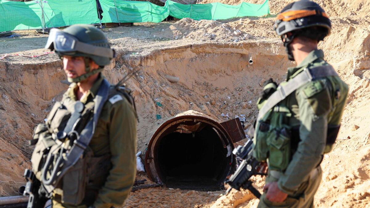 In this picture taken during a media tour organised by the Israeli military on December 15, soldiers stand at the entrance of a tunnel that Hamas reportedly used to attack Israel through the Erez border crossing on October 7. — AFP