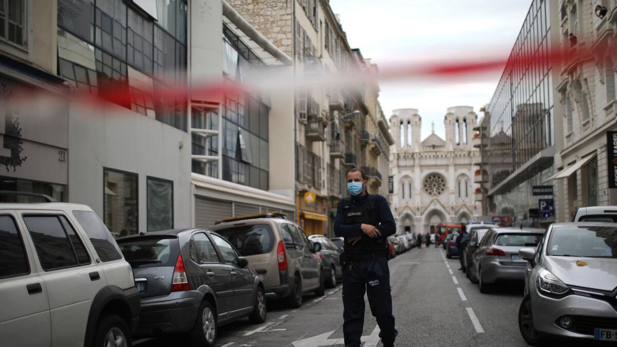 A police officer works behind a restricted zone near the Notre Dame church in Nice, southern France, after a knife attack took place on Thursday, Oct. 29. AP