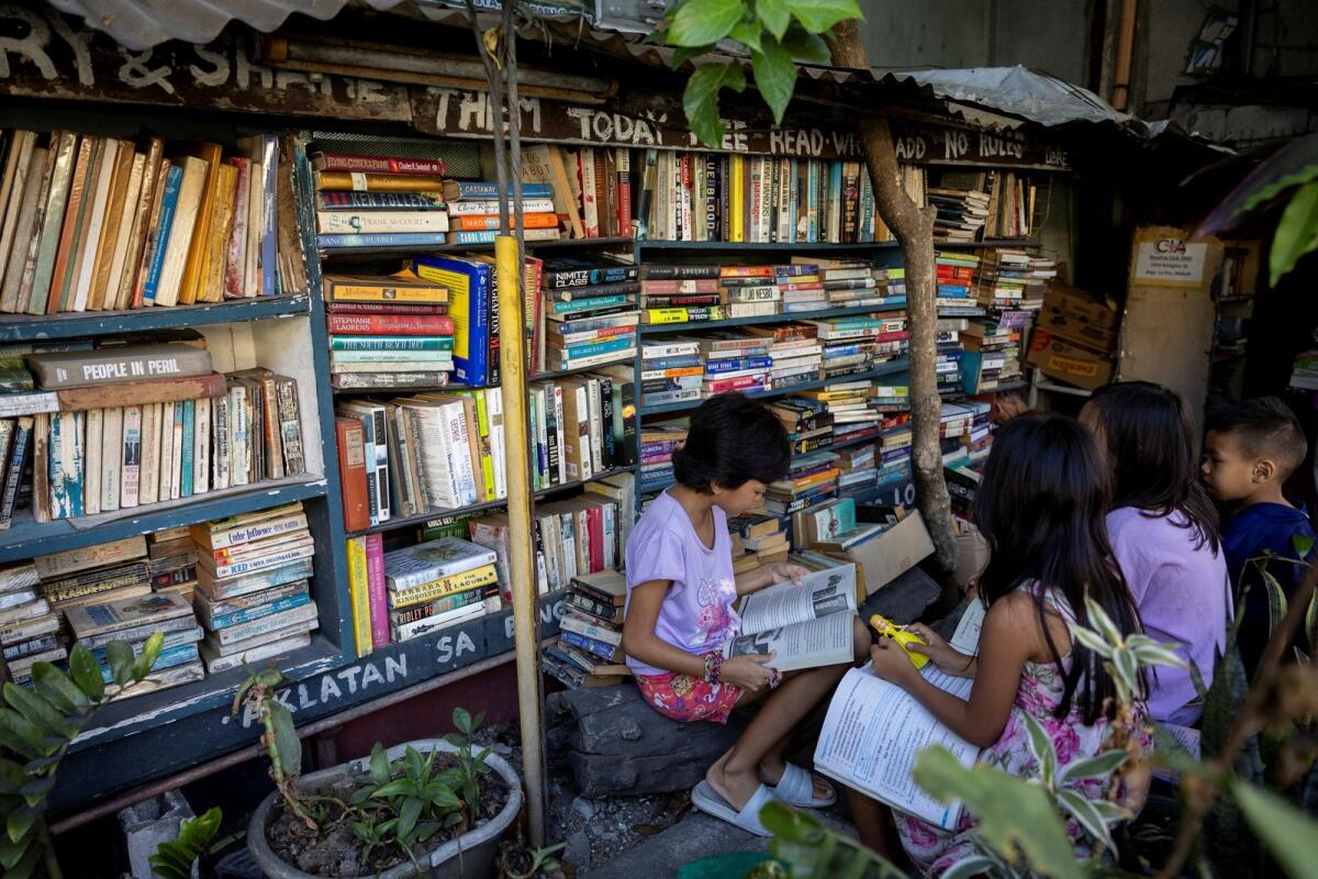 Children read books at Hernando Guanlao's communal library in Makati, Metro Manila, Philippines, on February 7, 2024. — Reuters