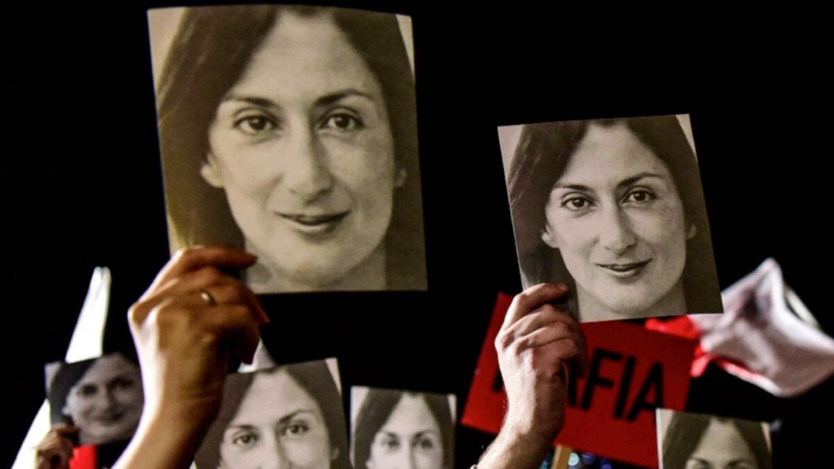 People holding placards reading 'Mafia Government' and photos of killed journalist Daphne Caruana Galizia, stage a protest called by Galizia's family and civic movements in 2019. — AFP file
