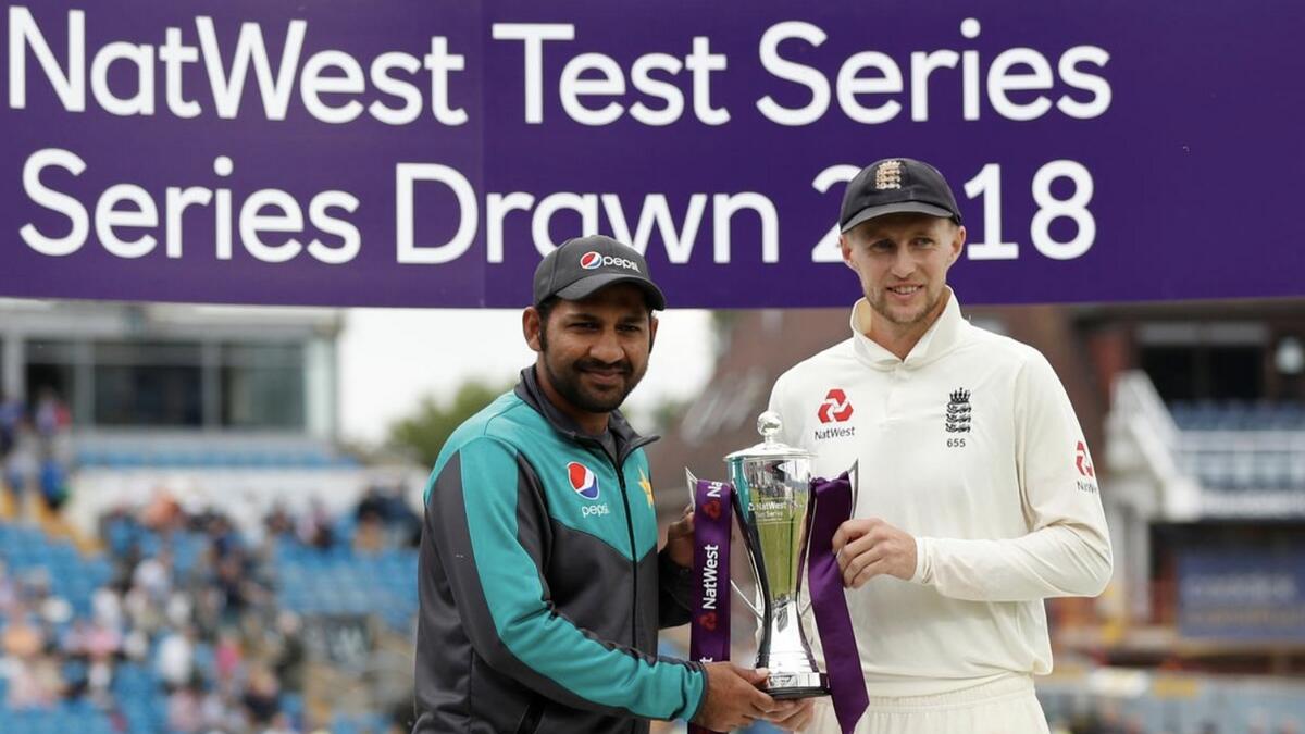 England's Joe Root (right) and Pakistan's Sarfraz Ahmed pose with the trophy after the 2018 series was drawn. - Agencies