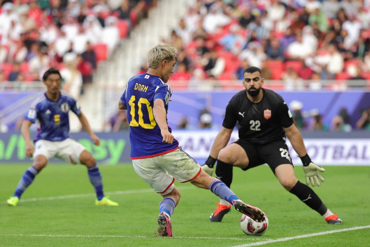 Japan's midfielder Ritsu Doan controls the ball as Bahrain's goalkeeper Ebrahim Lutfallah attempt to block his move. — AFP