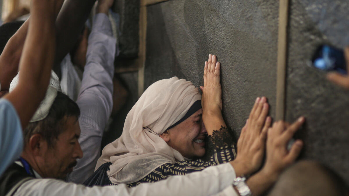 In this Monday, Sept. 21, 2015 photo, a Muslim pilgrim cries while praying at the Kaaba, the cubic building at the Grand Mosque