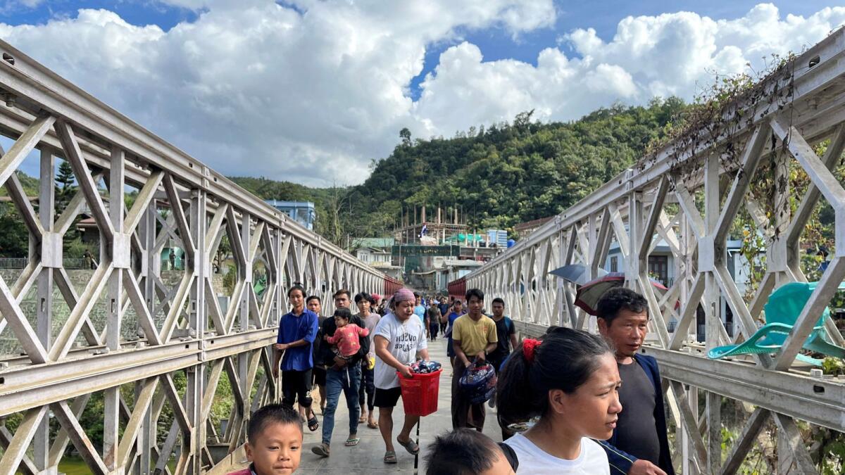 People who fled Myanmar carry their belongings across a bridge that connects Myanmar and India at the border village of Zokhawthar, Champhai district in Mizoram  in 2023. — Reuters file