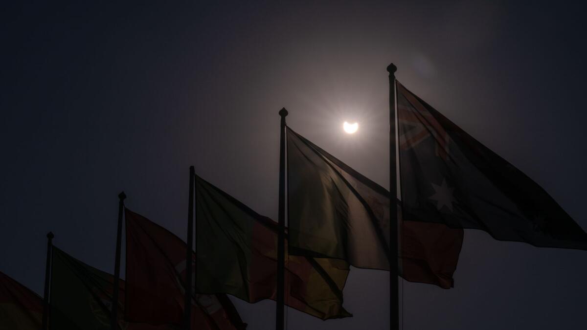 The eclipse glimpsed above the flags of the Fifa World Cup participant countries in Doha, Qatar, ahead of the 2022 Fifa World Cup 2022.
