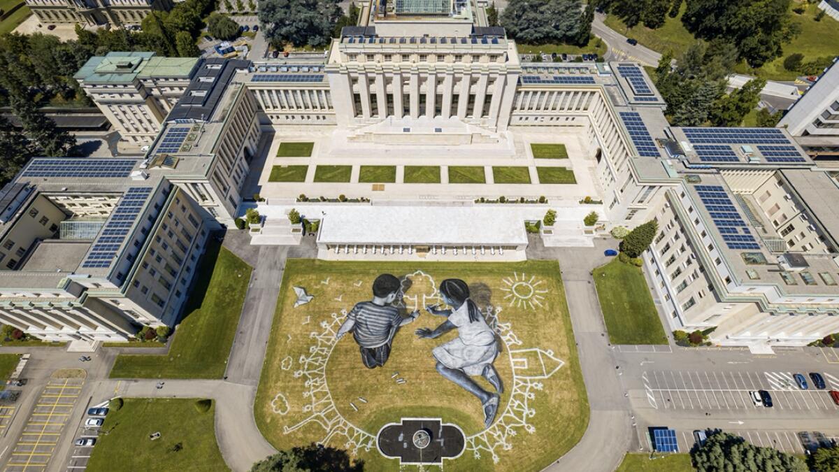 A view of artwork called 'World in progress' by French Saype made with an ecological mixture of chalk and charcoal and depicting two children kneeling in a circle as they draw a tree together to commemorate the 75th anniversary of the founding of the United Nations on the lawn of its European headquarters is pictured amid the coronavirus disease (Covid-19) outbreak in Geneva, Switzerland. Photo: Reuters
