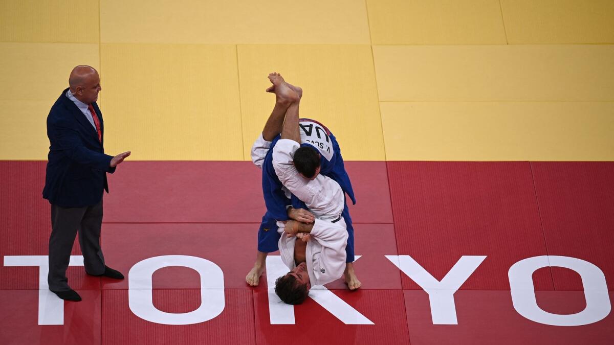 Sweden's Tommy Macias (white) and UAE's Victor Scvortov compete in the judo elimination round. (AFP)