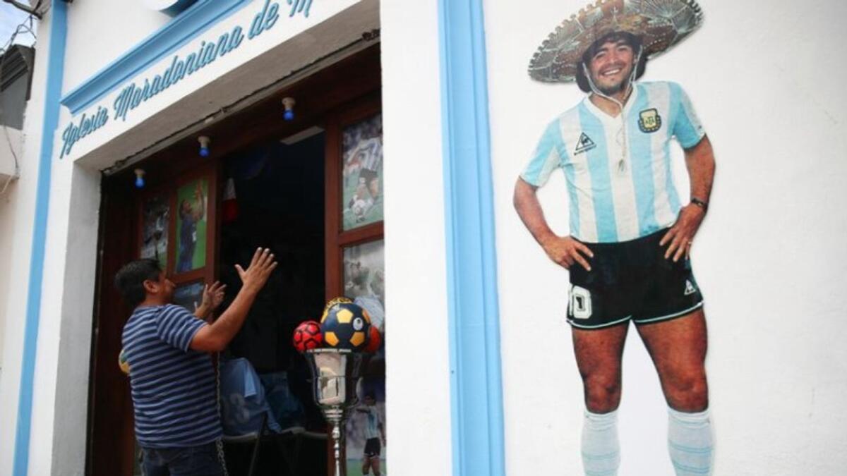 A fan kneels in front of the church built in memory of Diego Maradona in San Andres Cholula,  Puebla, Mexico. (Reuters)