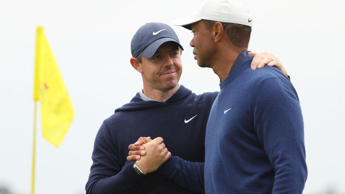 Rory McIlroy of Northern Ireland shakes hands with Tiger Woods of the United States during the Augusta Masters. - AFP File