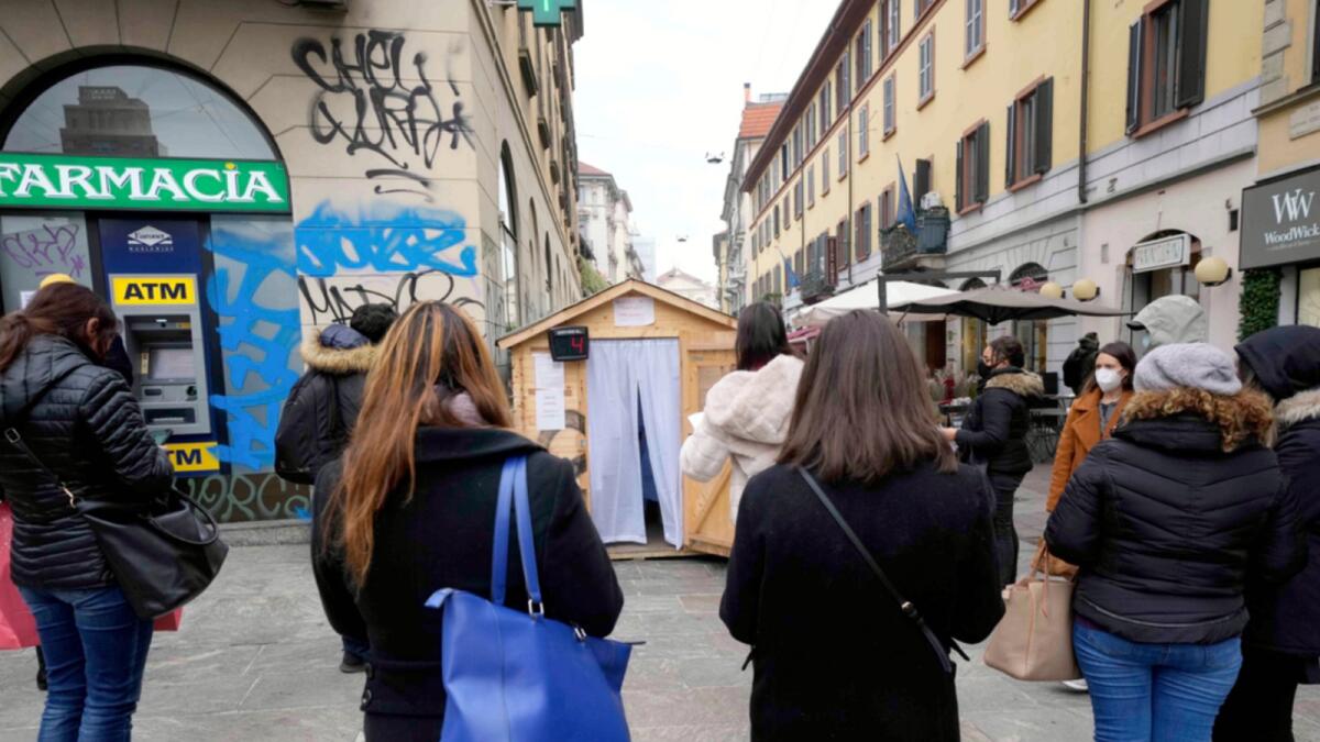 People line up at a mobile Covid testing site next to a pharmacy in Milan, Italy. — AP