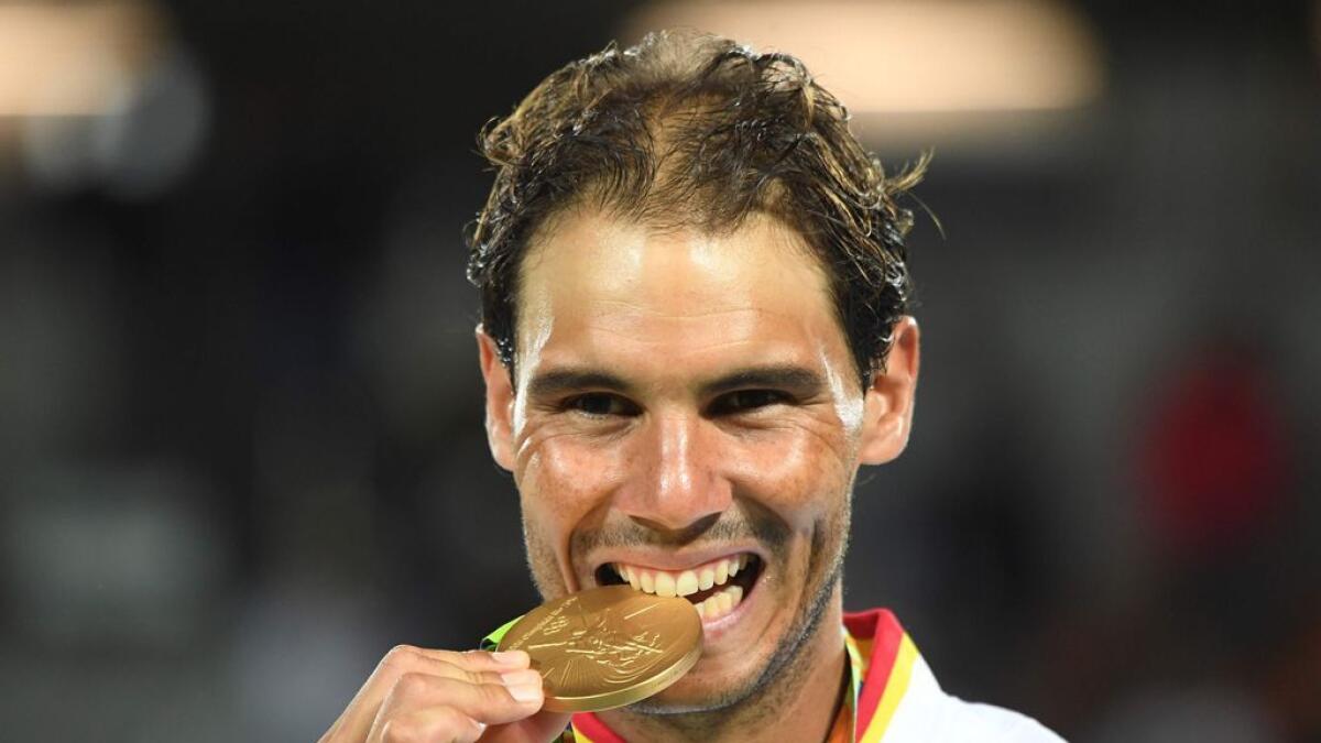 Spain's Rafael Nadal poses with his tennis doubles gold medal on the podium at the Rio Olympics.