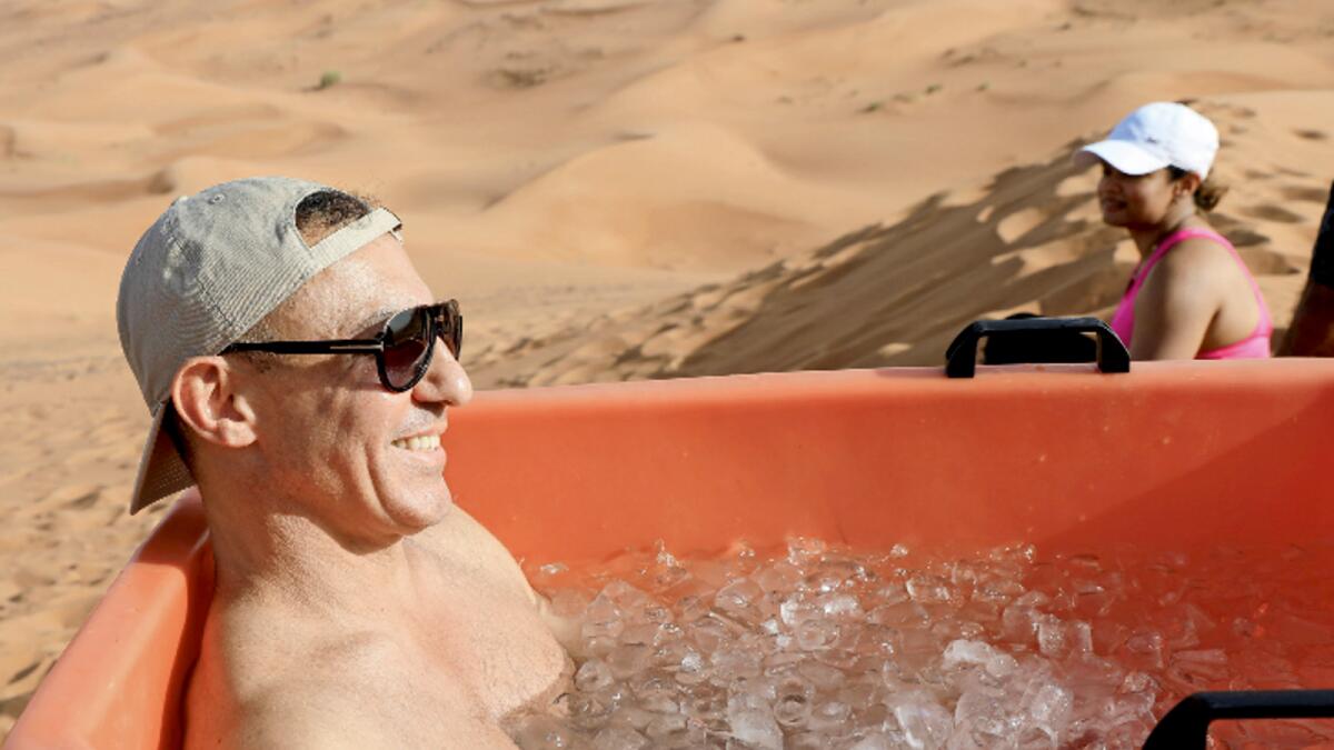 A participant sits in an ice bucket during an ice bath therapy session at the desert near Sharjah. Photo: Reuters