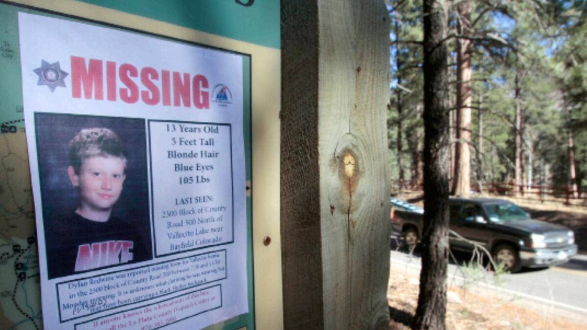 A photo shows a missing poster of 13-year-old Dylan Redwine on a trail head sign next to Vallecito Reservoir in Vallecito in 2012. — AP file