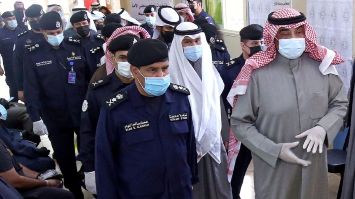 Kuwaiti Prime Minister Sheikh Sabah Al Khaled Al Sabah (R)  arrives to cast his votes at a polling station in Kuwait City during parliamentary elections on December 5. — AFP