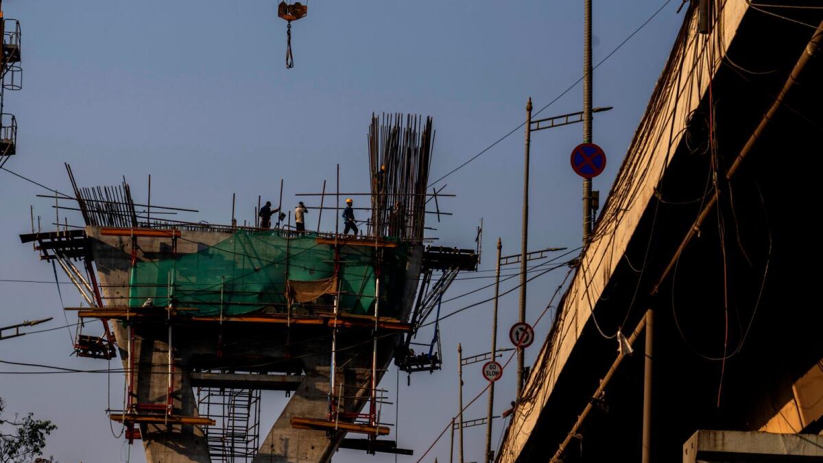 Labourers work on the construction of a bridge in Mumbai. India’s economy is projected to grow seven per cent in the fiscal year ending in March. The government forecasts growth of six per cent to 6.5 per cent next year. — AP 