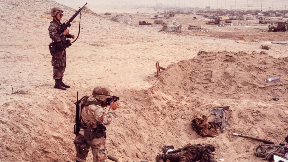 American soldiers clicking souvenir photos of dead Iraqi soldiers in Kuwait, 1991.