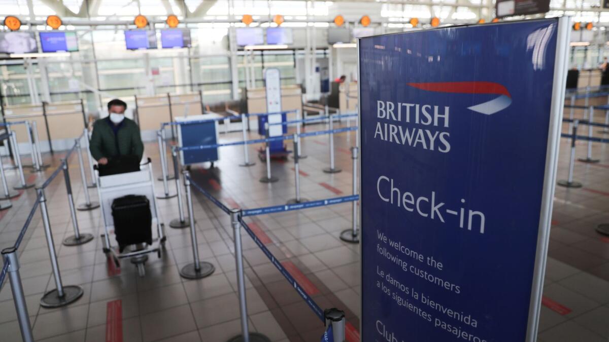 A passenger pushes a trolley at an almost empty British Airways check-in passengers area at the International Airport of Santiago.