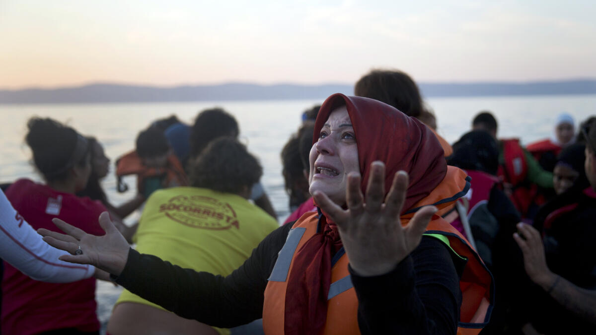 A Syrian woman reacts as she arrives aboard a dinghy after crossing from Turkey, to the island of Lesbos, Greece, on Saturday, Sept. 19, 2015. AP photo