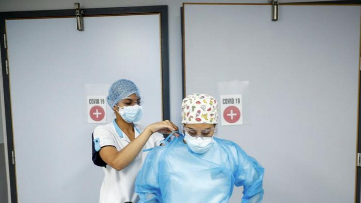 A nurse adjusts the protective suit of her colleague at the coronavirus treatment unit of a hospital in Brussels, Belgium.