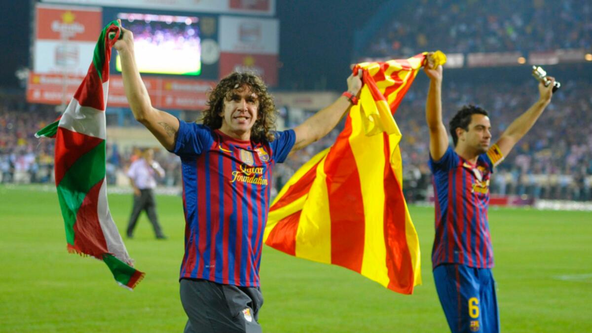 Former Barcelona captain Carles Puyol (left) with Xavi. — Reuters file