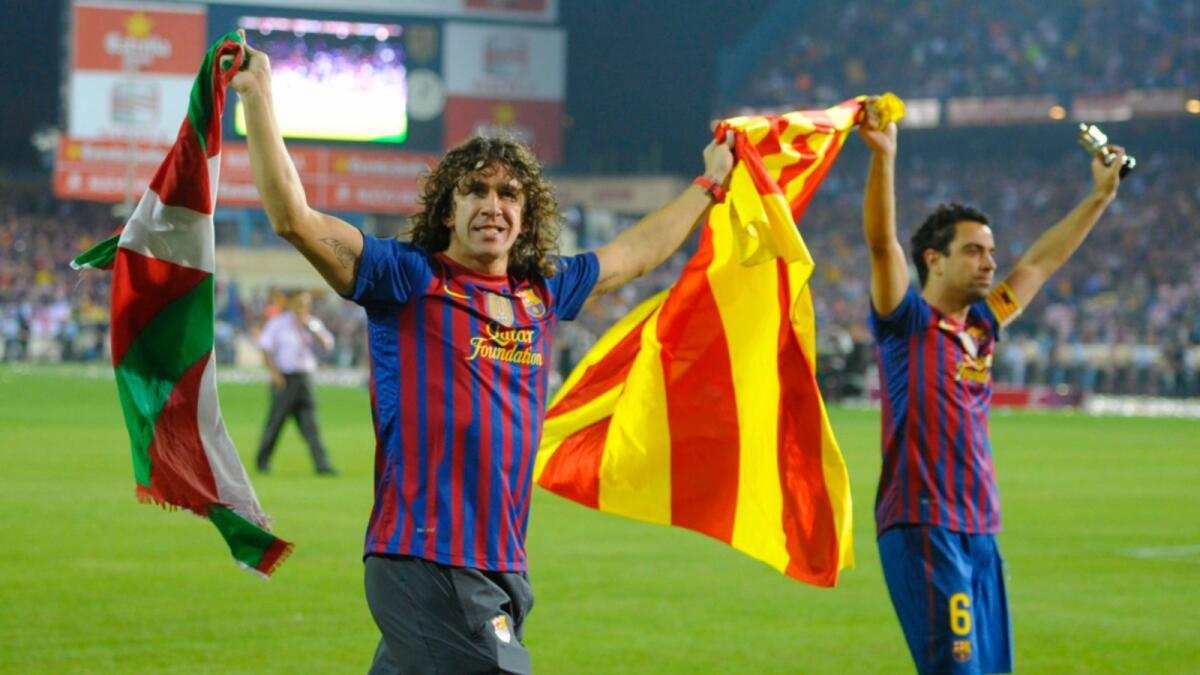 Former Barcelona captain Carles Puyol (left) with Xavi. — Reuters file