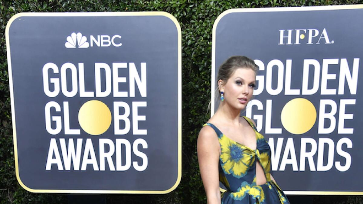 Taylor Swift stood out among a sea of monochrome looks in an Etro navy and yellow silk floral ball gown
