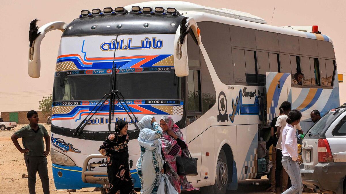 People disembark off a passenger bus at the Multaga rest-stop near Ganetti in Sudan's Northern State on April 25, 2023, about 300 kilometres northwest of the capital, on Tuesday. — AFP