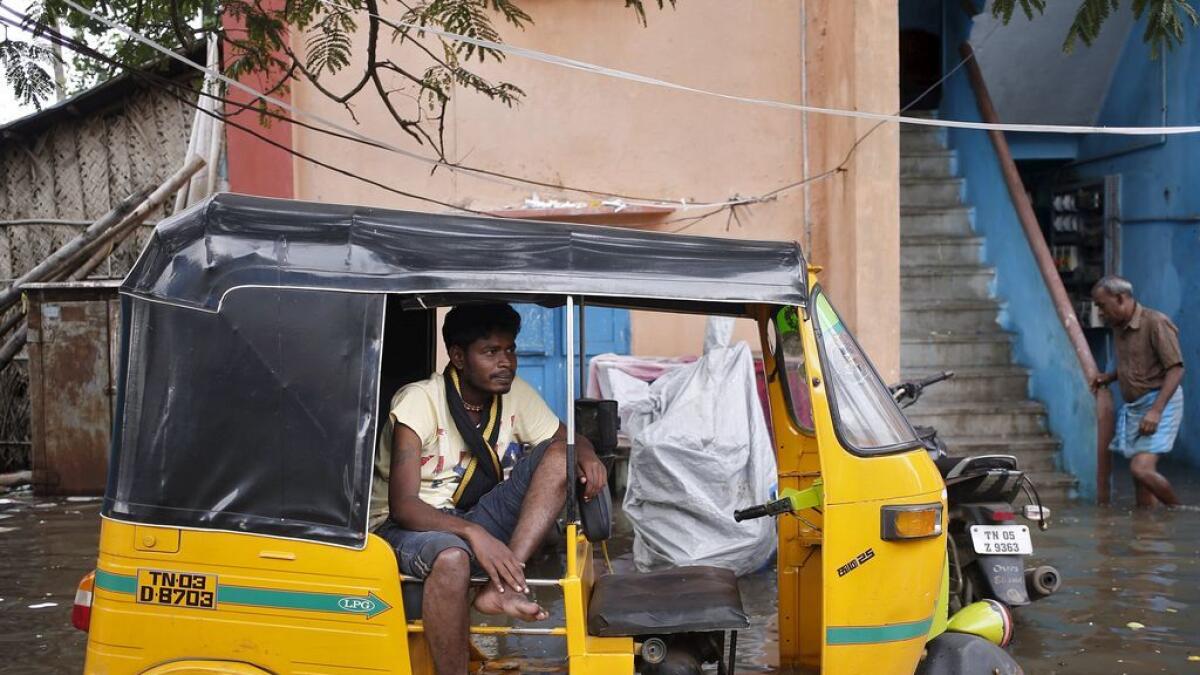 A man sits in an auto-rickshaw in a flooded area in Chennai, India.