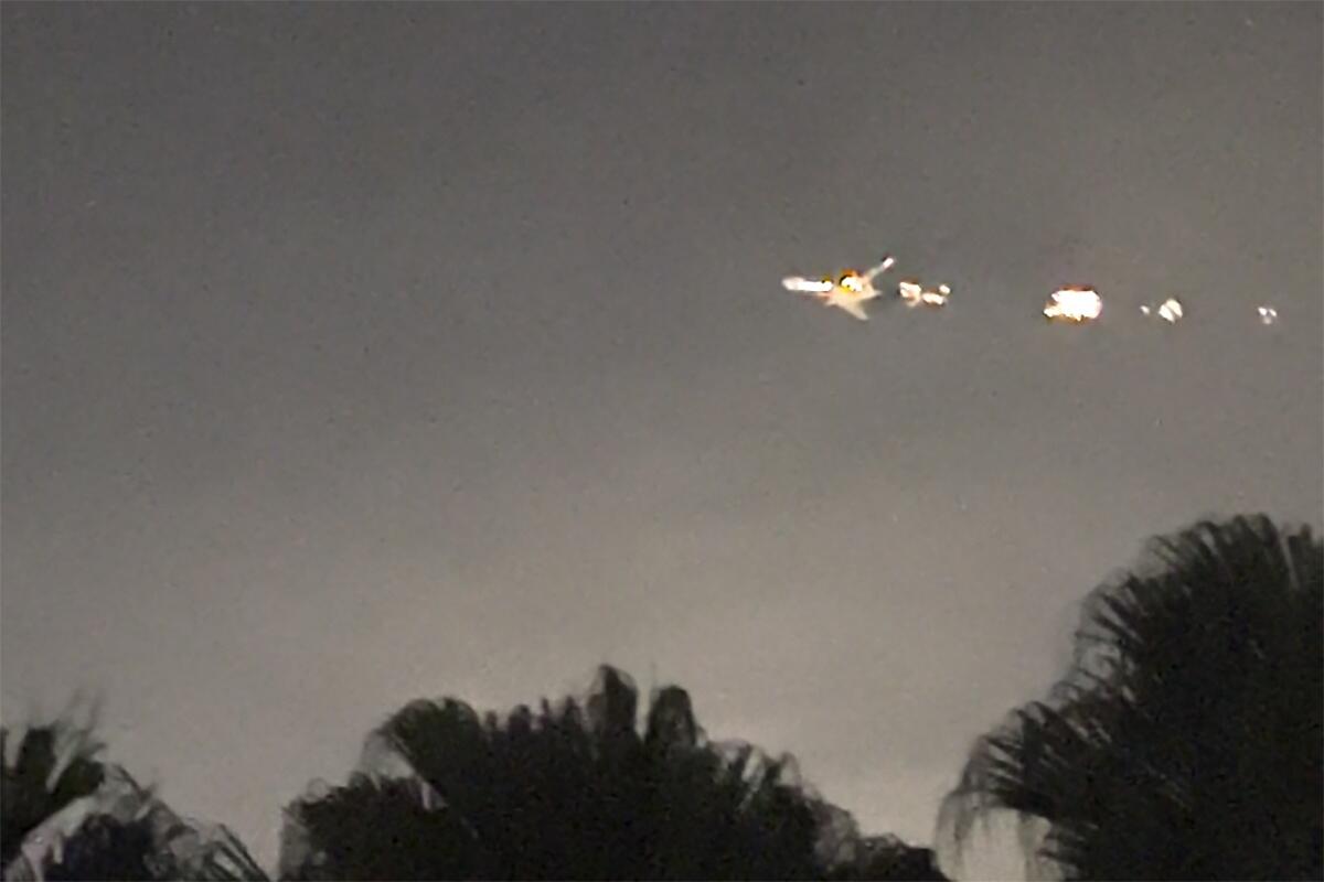 This image taken from video provided by Melanie Adaros shows sparks shooting from a cargo plane before making an emergency landing at Miami International Airport. — AP