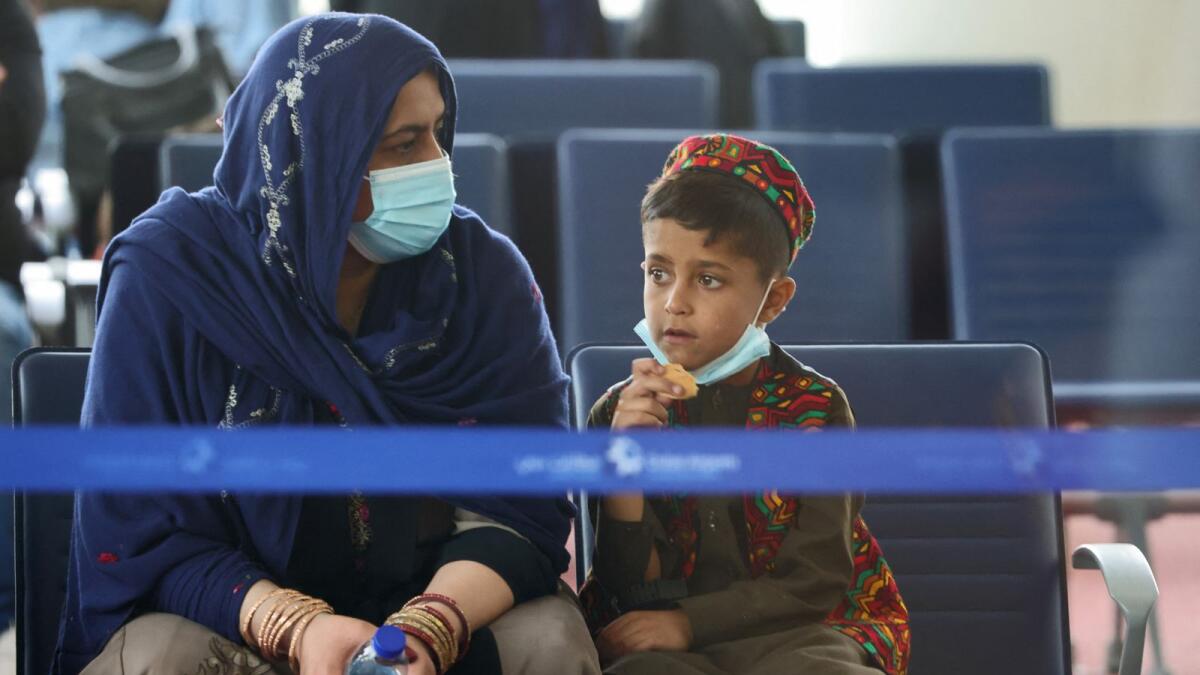 Evacuees from Afghanistan sit in a hall upon their arrival at Al Maktoum International Airport ahead of their travel on to the UK. Photo: AFP