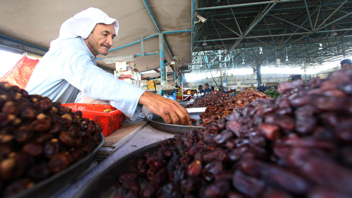 A man arranges dates at the Fruit and Vegetable Market in Al Tawir in Dubai.- Photo  Dhes Handumon/Khaleej Times