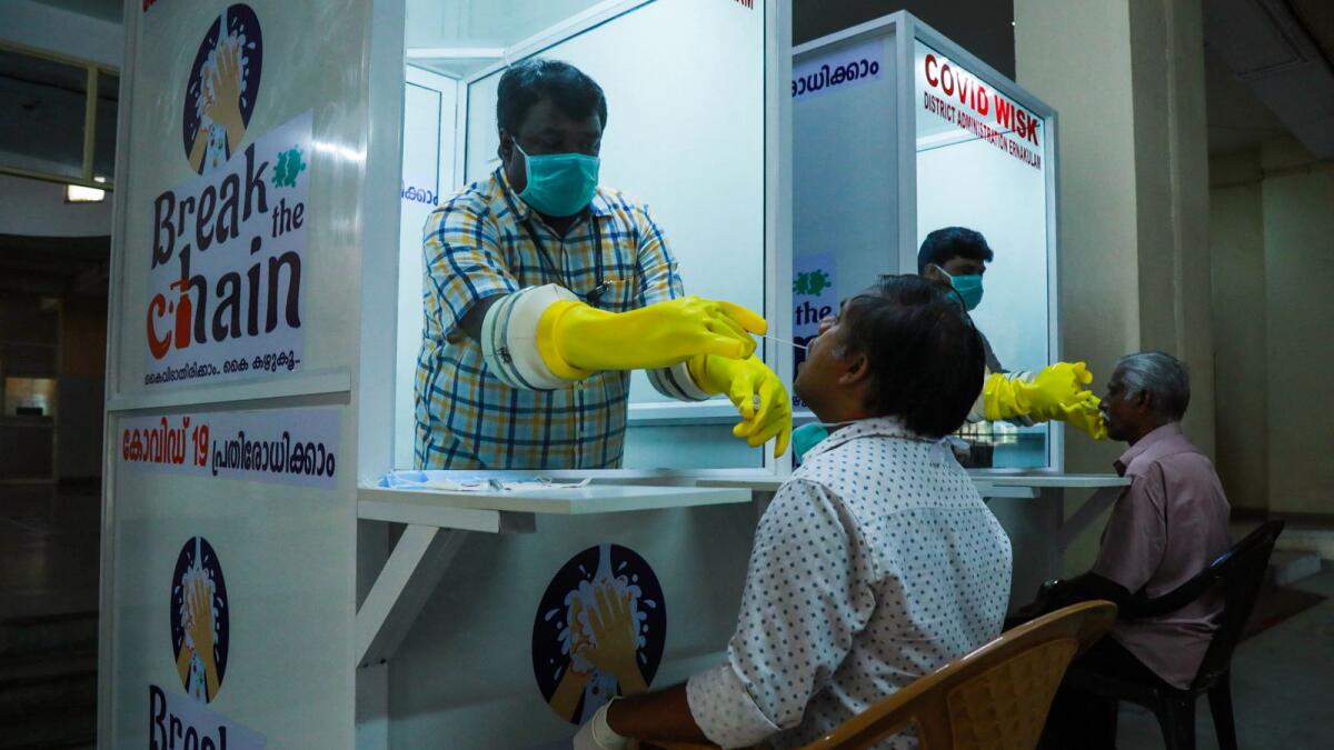 Medical staff collect samples from people at Walk-In Sample Kiosk (WISK) to test for Covid-19 at Ernakulam Medical College in Kerala. — AFP file