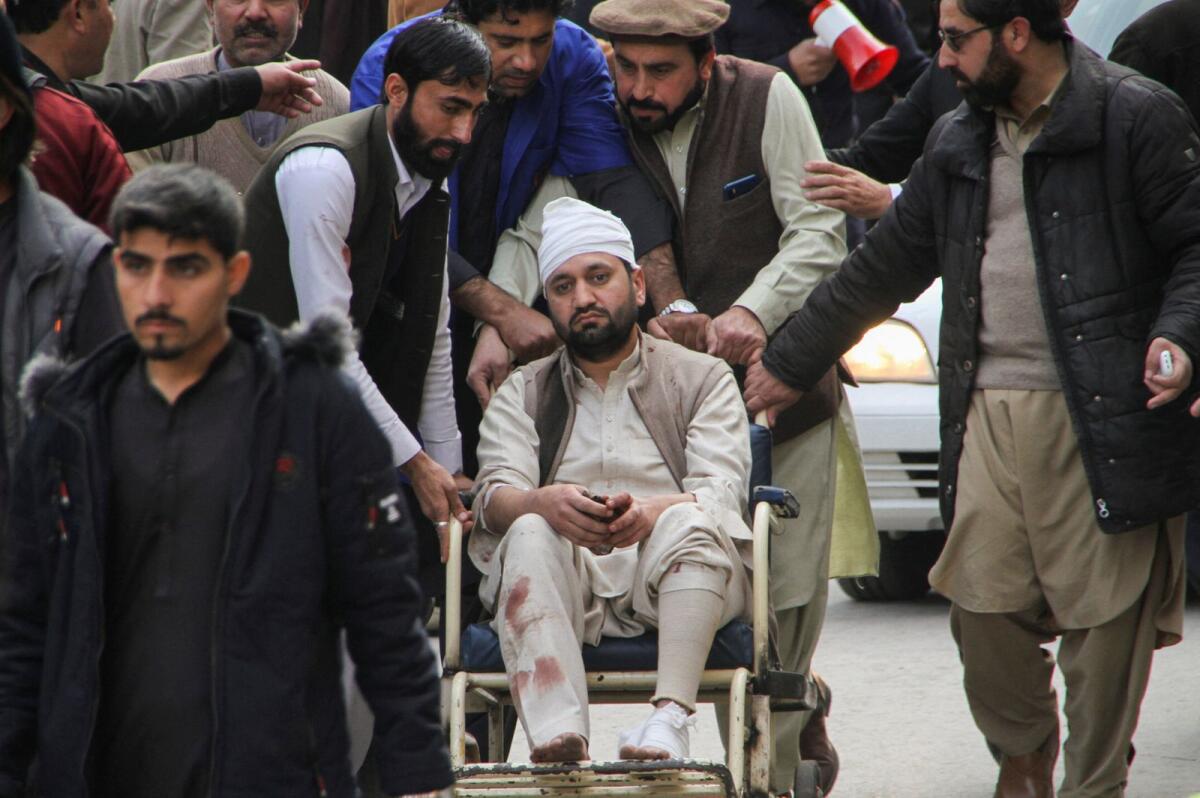 Men move an injured victim on a wheel chair, after a suicide blast in a mosque, at hospital premises in Peshawar, Pakistan January 30, 2023. Photo: Reuters