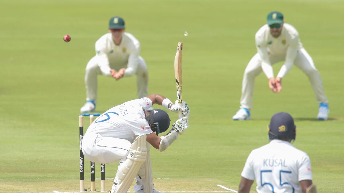 Sri Lanka's Dimuth Karunaratne (centre) ducks for a bouncer during the opening day of the first Test against South Africa. — AFP