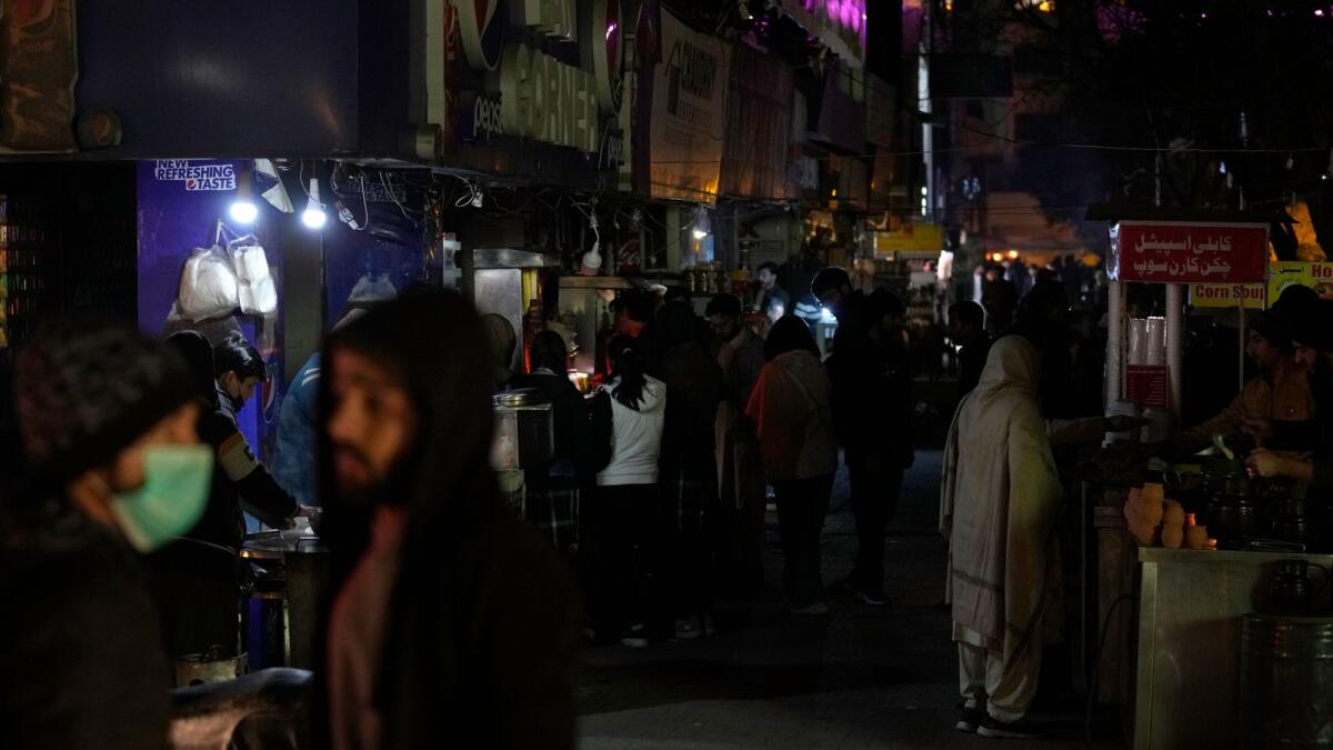 People visit a market, where some shopkeeper are using generators for electricity during a national-wide power breakdown, in Islamabad, Pakistan, on Monday. — AP