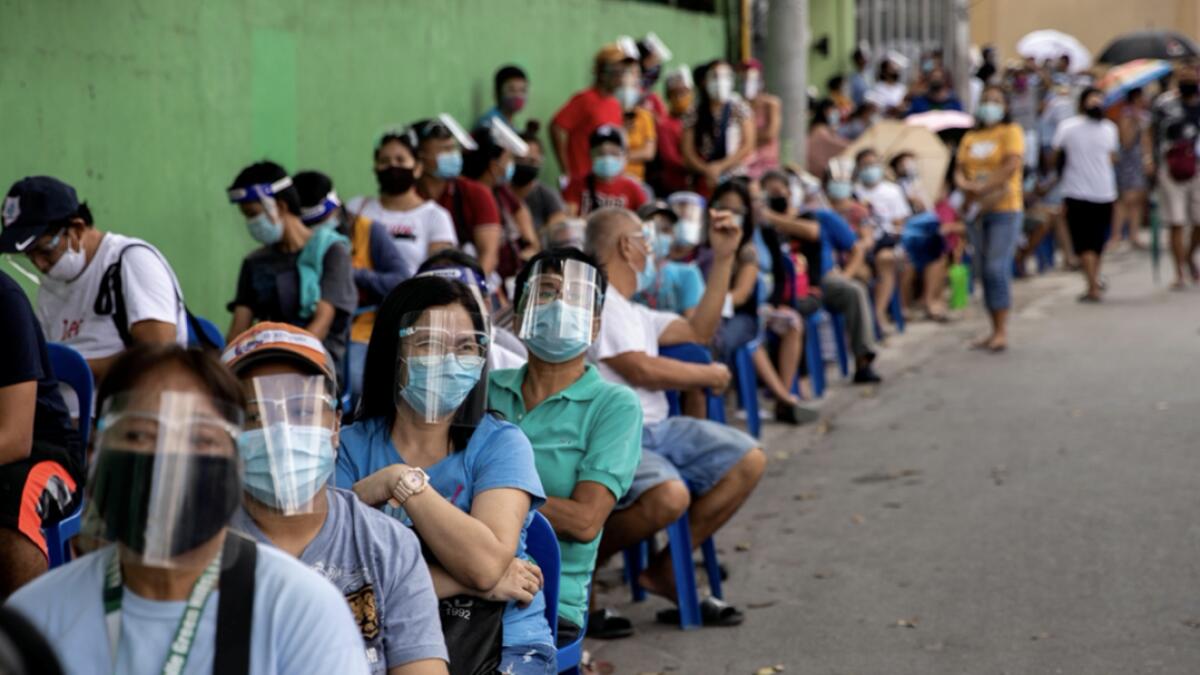 Filipinos queue for cash subsidy from the government amid the coronavirus disease (Covid-19) outbreak, in Batasan Hills, Quezon City, Metro Manila, Philippines. Photo: Reuters
