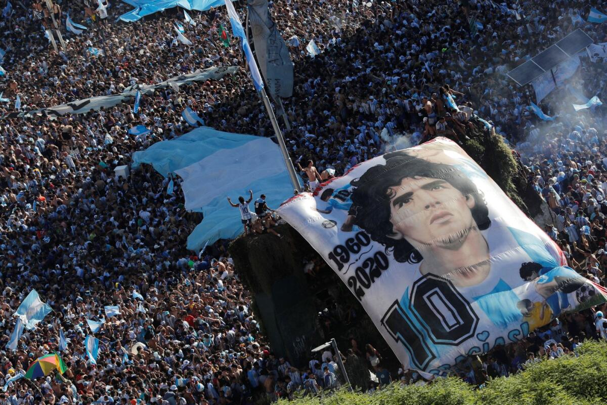 Argentina fans with a Diego Maradona banner celebrate after winning the World Cup. Photo: Reuters