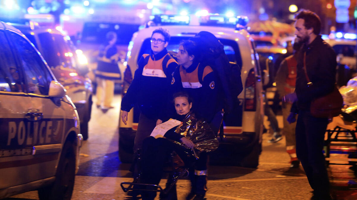 A woman is being evacuated from the Bataclan theater after a shooting in Paris, Friday Nov. 13, 2015. AP photo