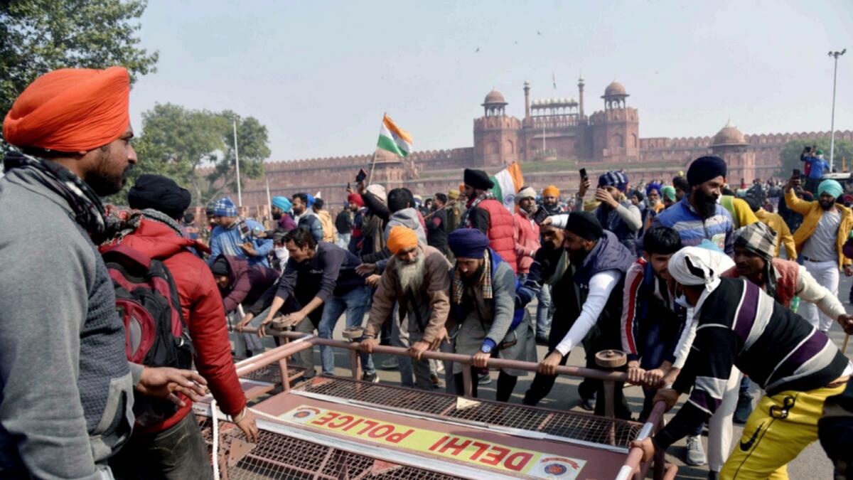 Protesting farmers break police barricades to enter Red Fort during a tractor rally in New Delhi on Tuesday. — ANI