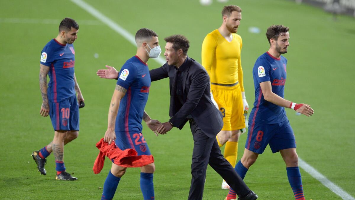 Atletico Madrid's Argentine coach Diego Simeone (centre) congratulates his players at the end of the Spanish League match against Real Betis. — AFP
