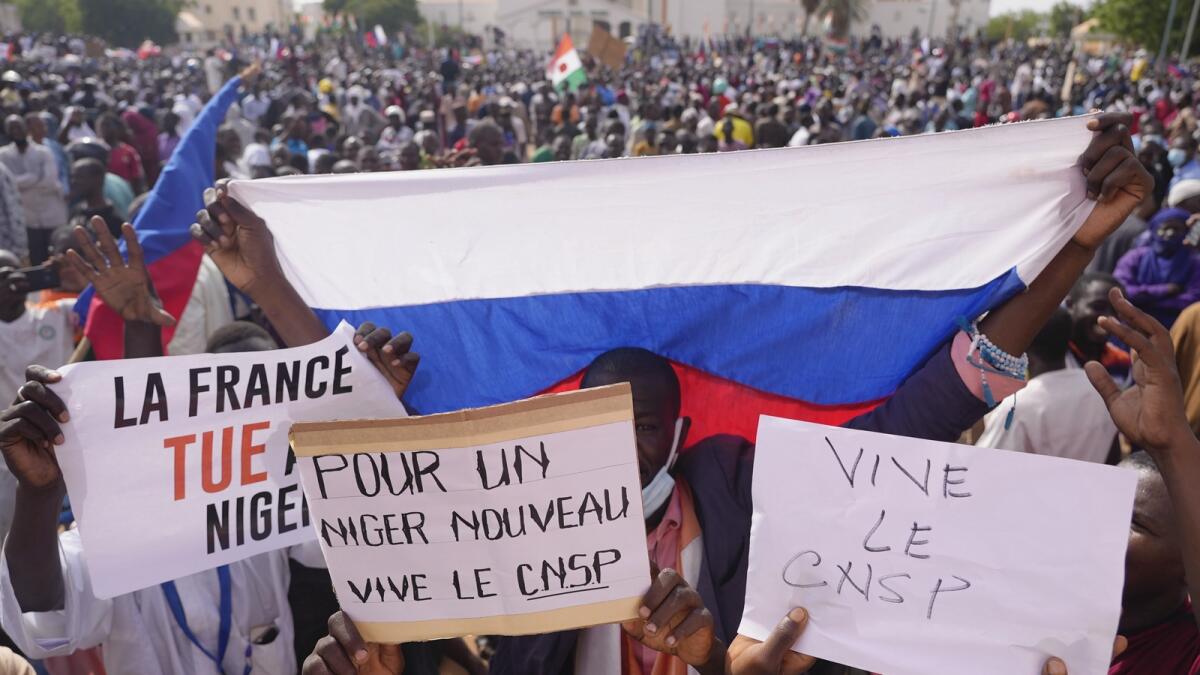 People holding a Russian flag and placards participate in a march called by supporters of coup leader Gen. Abdourahmane Tchiani in Niamey, Niger. — AP