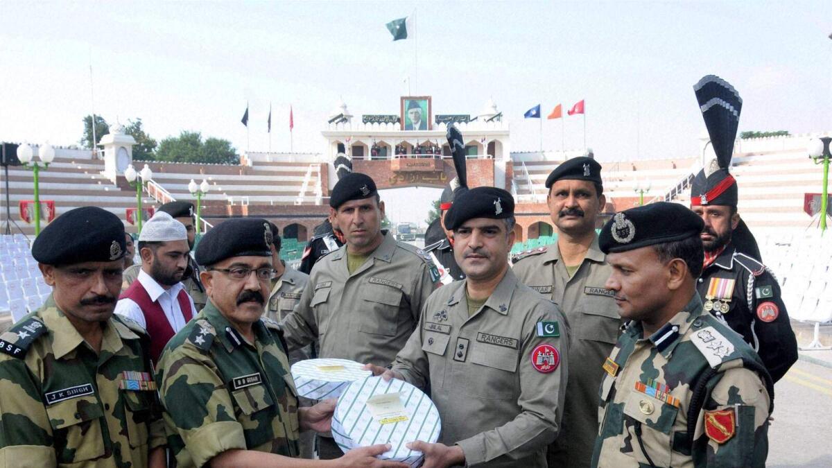 BSF officials offer sweets to Pakistani Rangers officials on the occasion of Diwali festival at Indo-Pak Attari-Wagha border on Wednesday.