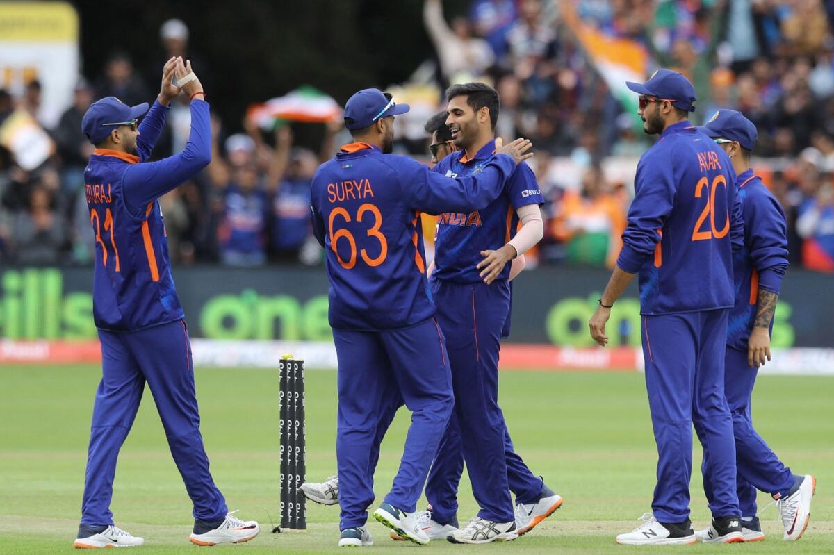 India's Bhuvneshwar Kumar (centre) celebrates with teammates after taking a wicket. (AFP)