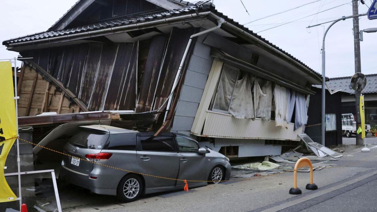 A car is seen crushed by a collapsed house after a strong earthquake in Suzu city, Ishikawa prefecture, northern Japan, Friday, May 5, 2023. (Kyodo News via AP)
