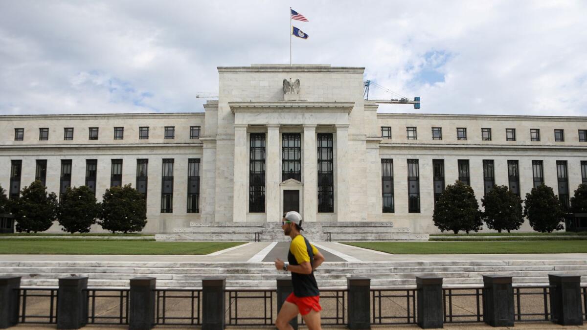 A jogger runs past the Federal Reserve building in Washington, DC. — Reuters
