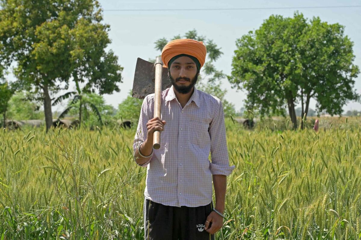 In this photograph taken on April 5, 2024, Gurpartap Singh, a farmer who will be voting for the first time in India's upcoming general election, poses in front of his wheat field at Chabba village on the outskirts of Amritsar. — AFP